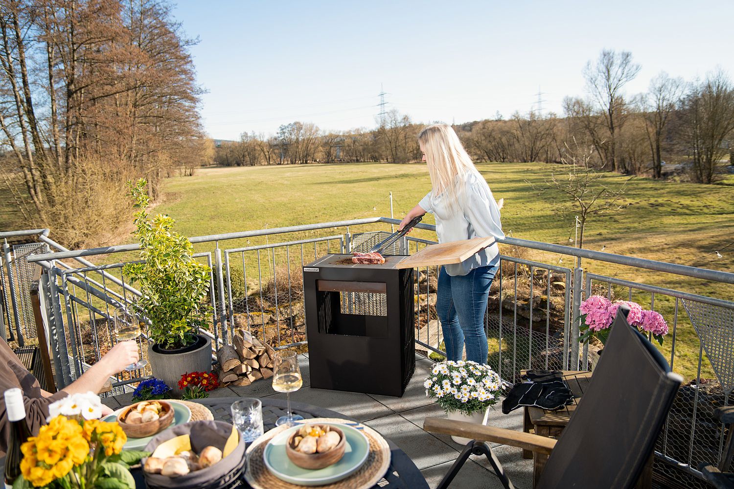 Nærbilde av plastføtter på Firepit bålpanne med grillrist rustfritt stål svart - Outdoorchef