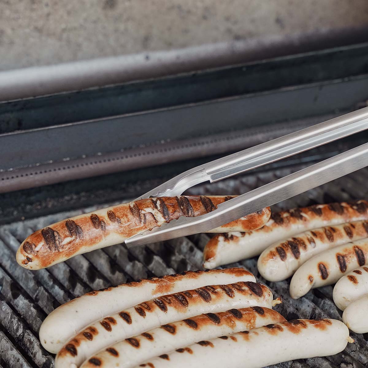 Grillpinsett rustfritt stål 53 cm - SANTOS i bruk over grill