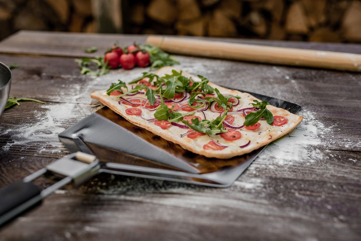 Pizzaspade rustfritt stål sammenleggbar 57 cm i bruk med pizza