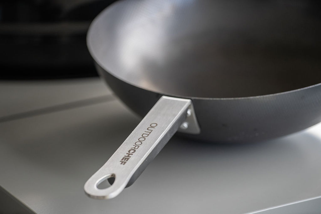 Detalj av håndtak på Wok karbonstål 33 cm med lokk og wokring Outdoorchef